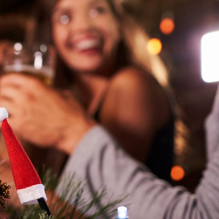Friends raise glasses at a holiday party.